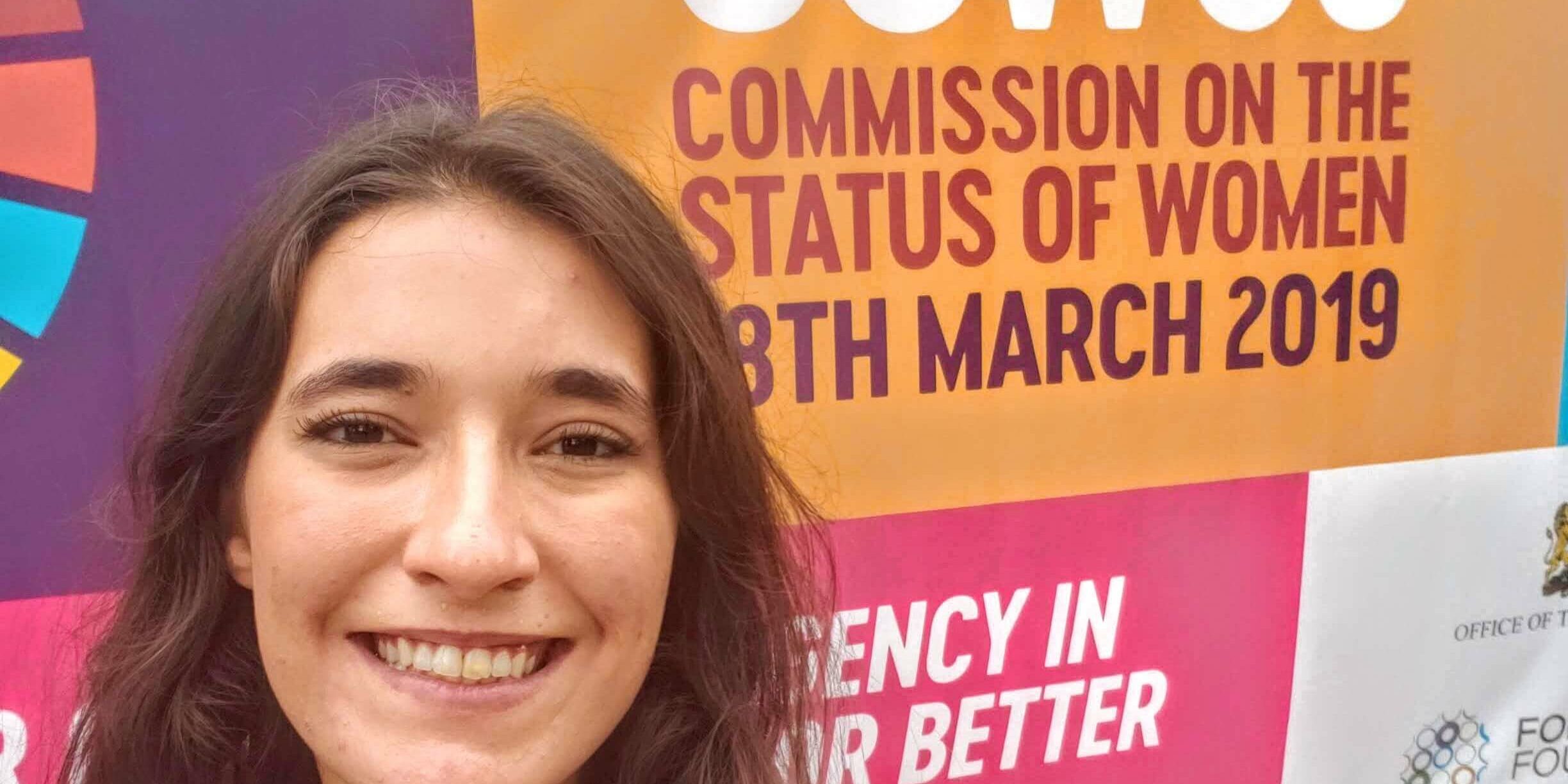 Luiza Kormann em frente a painel com os dizeres "CSW63 - Comission on the Status Of Women 8th March 2019"